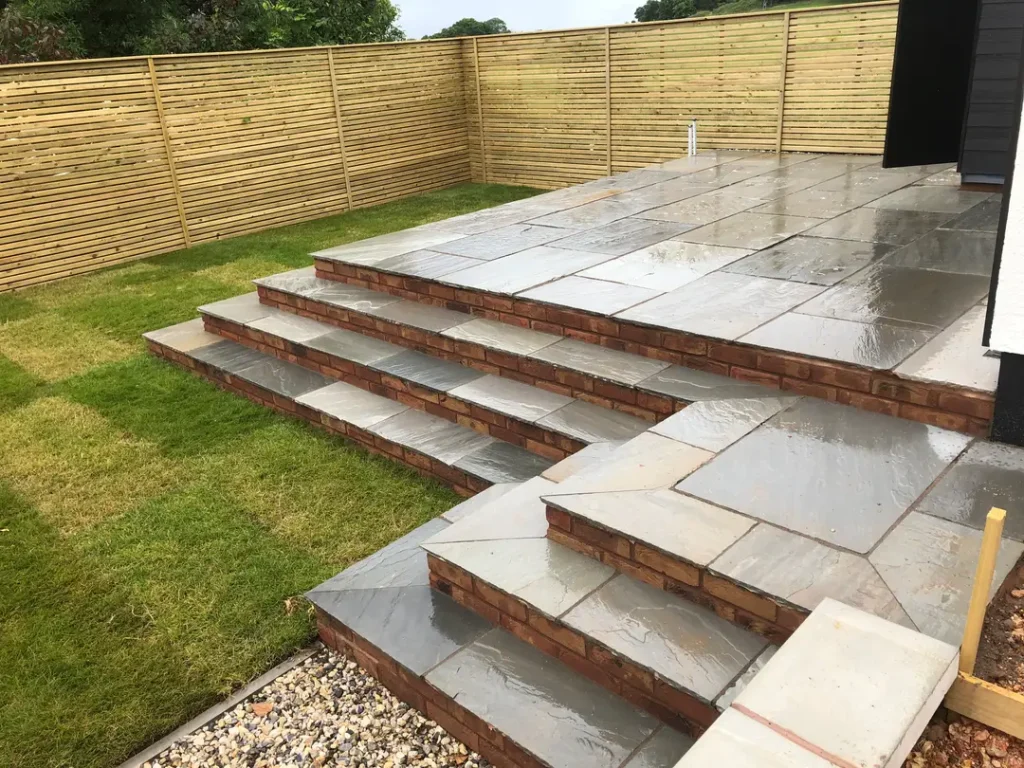 a patio with a fence and grass
